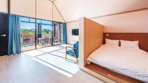 a bedroom with a bed and a sliding glass door at Ganghwa Aiem Glamping in Incheon