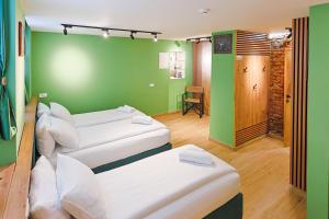 two beds in a room with green walls at FourMountains-Jahorina in Sarajevo +5 photos