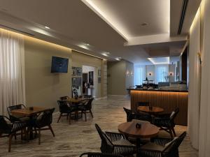 a restaurant with tables and chairs and a bar at Hotel Vila Zeus in Rinas