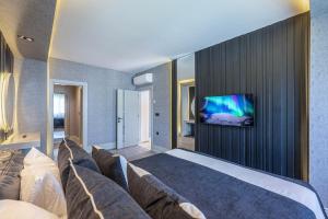 a bedroom with a bed and a tv on a wall at L'Oceanica Beach Resort in Kemer