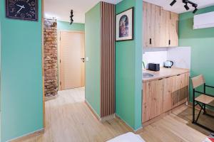 a kitchen with green walls and a table and a sink at FourMountains-Jahorina in Sarajevo