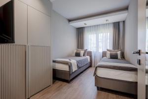 a bedroom with two beds and a tv and a window at L'Oceanica Beach Resort in Kemer