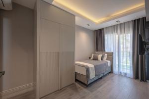 a bedroom with a bed and a large window at L'Oceanica Beach Resort in Kemer