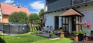 a backyard with a hot tub next to a house at Apartmán U našich in Jeseník