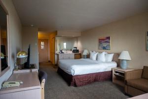 a hotel room with a large bed and a couch at Shilo Inn Mammoth Lakes in Mammoth Lakes