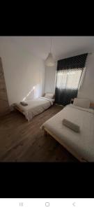 a bedroom with two beds and a window at Le Jardin Aparthotel in Taza