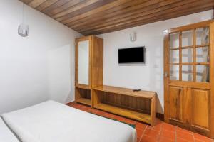 a bedroom with a bed and a tv on a wall at Lilly's Valley Resort in Kodaikānāl