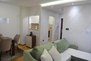 a living room with a green couch and a table at Rio Apartmani Ub 3 in Ub +11 photos