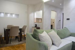 a living room with a green couch and a table at Rio Apartmani Ub 3 in Ub