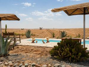 a group of people in a swimming pool in the desert at Dar Inacamp in El Mjed