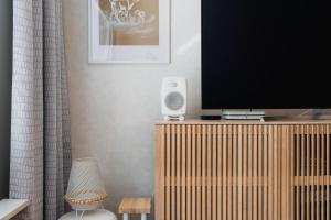 a living room with a television on a wooden entertainment center at Nordic Nova II by Elys Collection in Rovaniemi