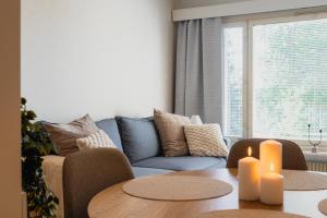 a living room with a couch and a table with candles at Nordic Nova II by Elys Collection in Rovaniemi +10 photos