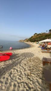 a sandy beach with umbrellas and the ocean at Green House in Briatico