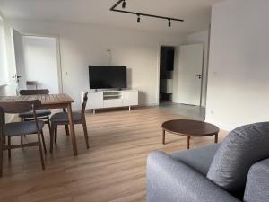 a living room with a table and a tv at Apartamenty u Rybaka in Stężyca