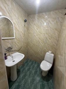 a bathroom with a white toilet and a sink at Guest House Citrus in Kobuleti