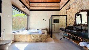 a bathroom with a tub and a sink and a toilet at LA PIANTA - Seu refúgio na Vila de Monte Verde in Monte Verde +266 photos