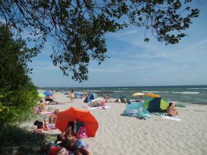 a group of people laying on a beach with umbrellas at Gaestehaus Vogelsang in Sierksdorf