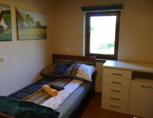 a bedroom with a bed with a teddy bear on it at Plantacja Wierzby Agroturystyka in Haczów