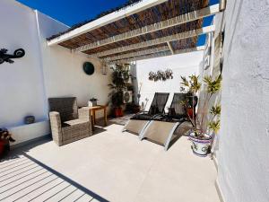 a patio with two chairs and a table and awning at Fabulous 2 bed-townhouse with large rooftop! in Estepona