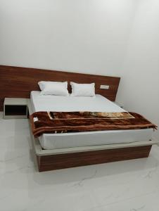 a bedroom with a bed with a wooden headboard at Shree Vishwakarma place in Khātu