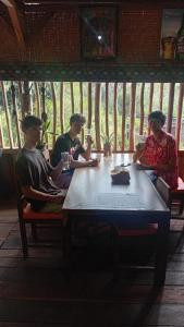 a group of people sitting around a table at Komachi House in Limbung