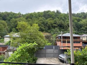 a view of a house with a fence and trees at Guest House GT in Oni