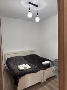a bedroom with a bed with a black blanket and a fan at Guest House GT in Oni
