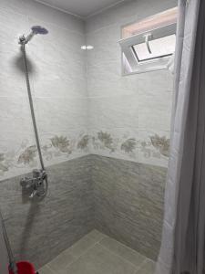 a bathroom with a shower with a window and a shower at Guest House GT in Oni +4 photos