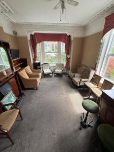 a living room filled with furniture and a large window at The Kirkdale Hotel in Croydon