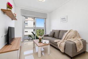 a living room with a couch and a table at Aparthotel Laguna Rosa in Los Montesinos