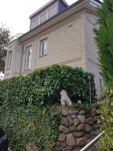 a house with a hedge in front of a building at Haus Sonne _ Meer in Sierksdorf