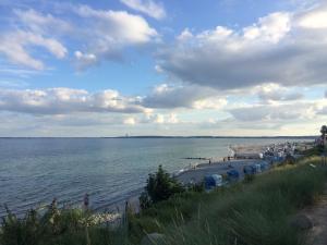 a beach with umbrellas and people on the water at Haus Sonne _ Meer in Sierksdorf