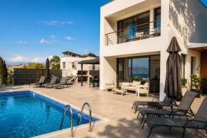a villa with a swimming pool and a house at Blue Infinity Villa 33 in Neo Chorio +9 photos
