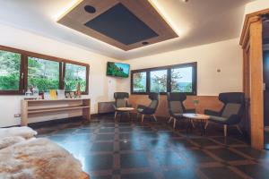 a room with chairs and a desk and a tv at Residence Des Alpes in Cavalese