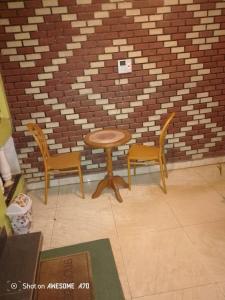 a table and two chairs in front of a brick wall at ALICIA Hôtel in Yaoundé