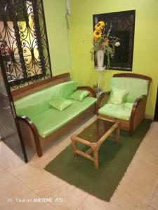 a living room with a couch and a chair and a table at ALICIA Hôtel in Yaoundé