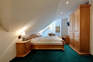 a bedroom with a large bed and a wooden cabinet at Hotel Sachsenklemme in Fortezza