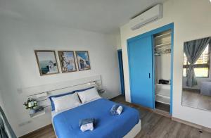 a bedroom with a blue bed and a blue door at SantoriniRD Terraza con vista a la laguna y 2 baños in Punta Cana
