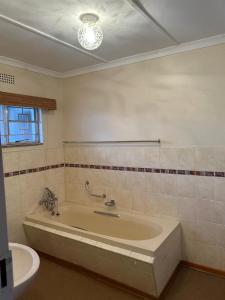 a bathroom with a large tub and a sink at Halkett Corner in Kimberley