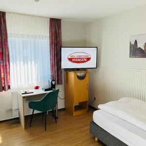 a hotel room with a bed and a desk and a sign at Hotel & Wirtshaus Hansen in Bergisch Gladbach