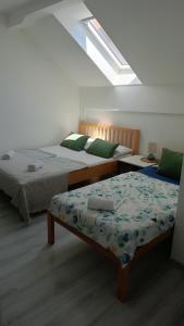 a bedroom with two beds and a skylight at Danin's Home in Tuzla