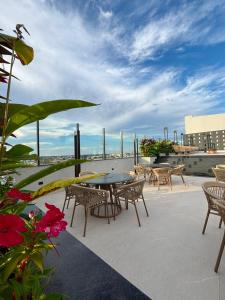 a patio with a table and chairs and flowers at Grand Maison Hotel in Porto Velho