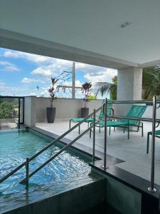 a house with a swimming pool with chairs and a patio at Grand Maison Hotel in Porto Velho