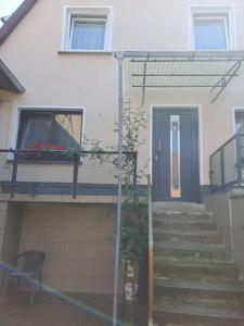 a house with a blue door and stairs at Camelia's Unterkunft in Sulzthal