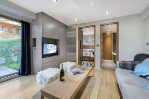a living room with a couch and a table at Résidence Les Sapins - Courchevel 1850 in Courchevel +3 photos