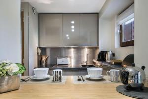 a kitchen with a counter with bowls and utensils at Résidence Les Sapins - Courchevel 1850 in Courchevel