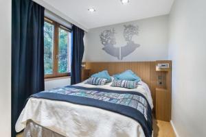 a bedroom with a large bed with blue pillows at Résidence Les Sapins - Courchevel 1850 in Courchevel