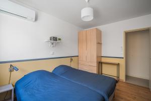 a bedroom with a blue bed and a cabinet at Au coeur de Valence - Parking gratuit - Entièrement climatisé in Valence
