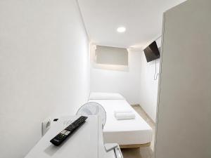 a room with a remote control sitting on a table at Hospedaje La Campana in Madrid +6 photos