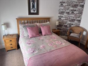 a bedroom with a bed with pink sheets and pink pillows at No 3 in Penrith